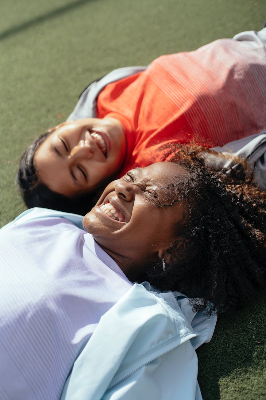 happy multiethnic girls laughing on lawn